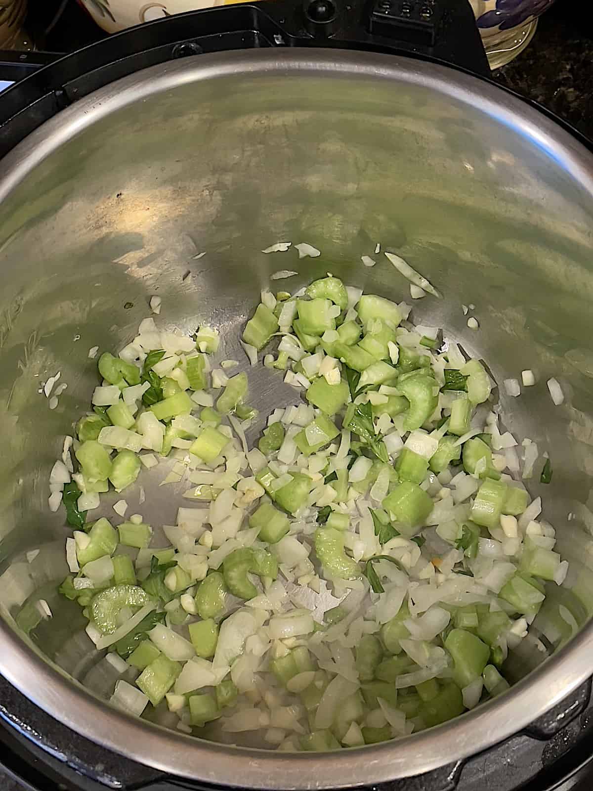 onions, celery and garlic cooking in the pressure cooker