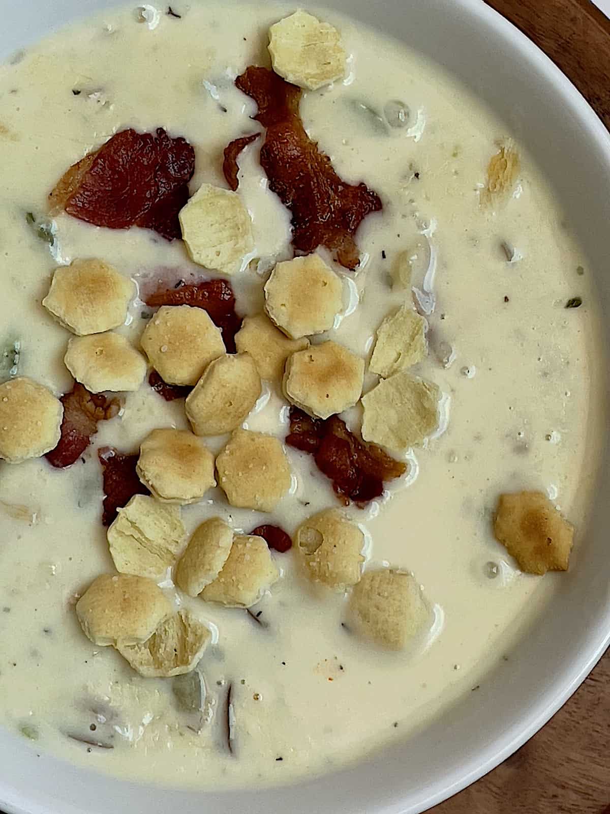clam chowder topped with oyster crackers and bacon bits
