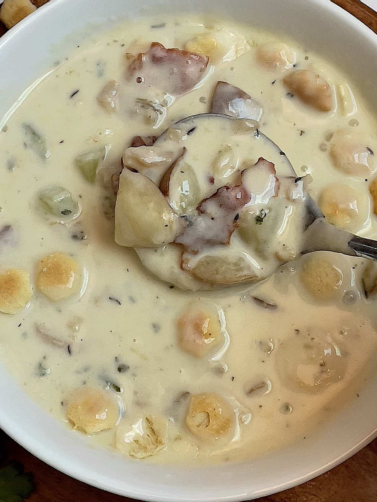 instant pot clam chowder in a spoon being dipped into a bowl