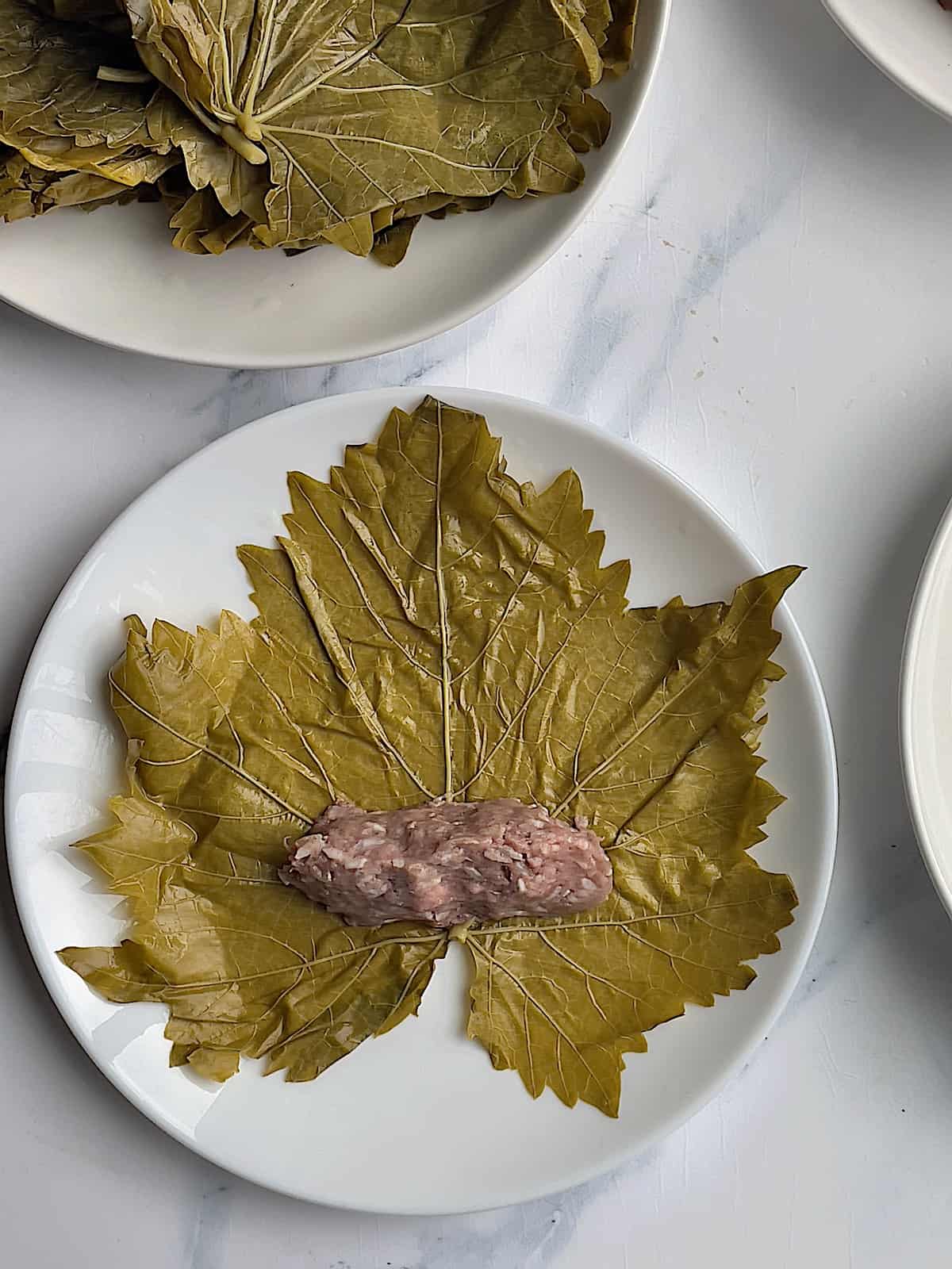 lamb and rice mixture on a flat grape leaf