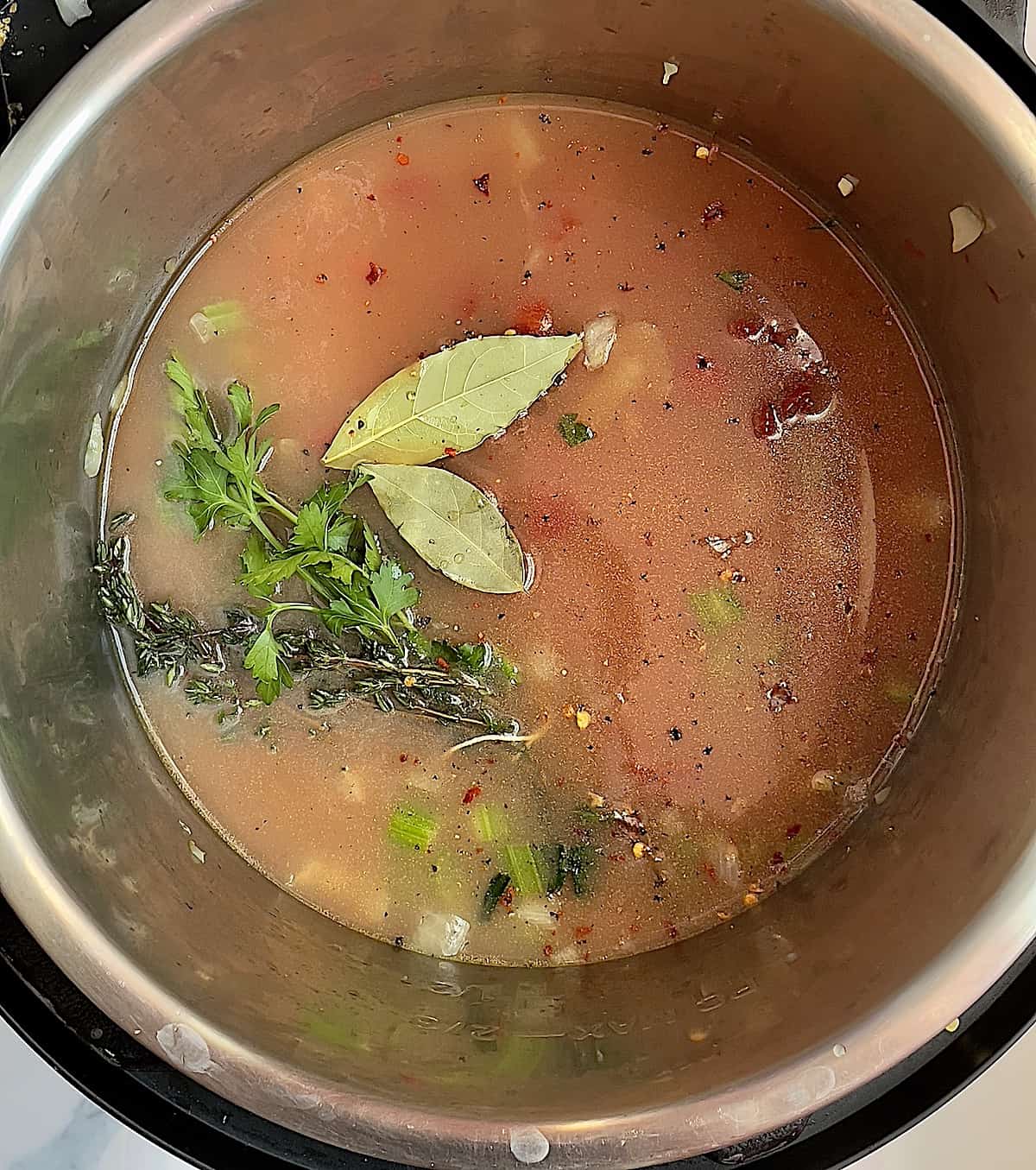 red clam chowder ingredients in a pressure cooker