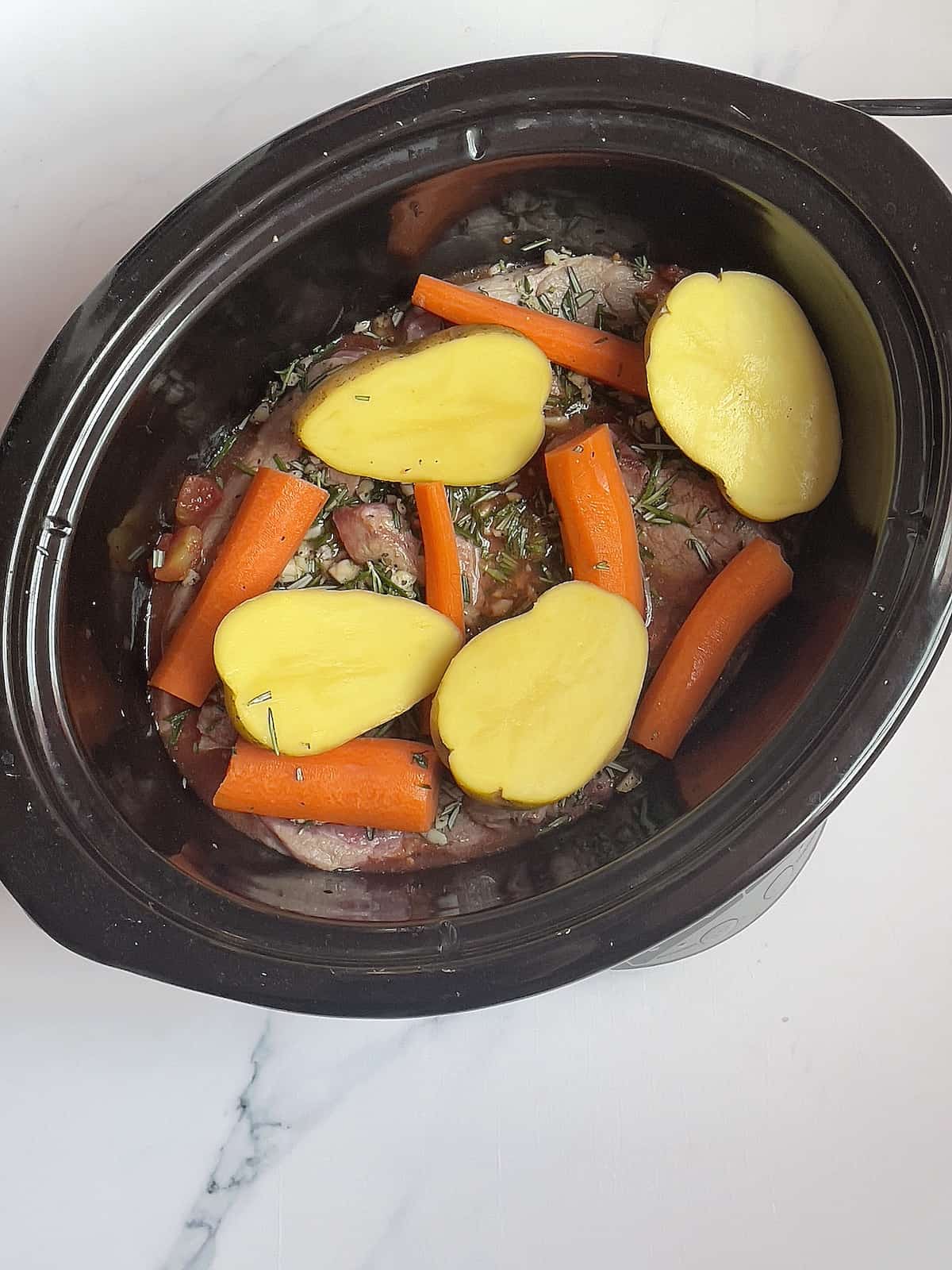 potatoes, carrots, lamb and sauce in a crockpot