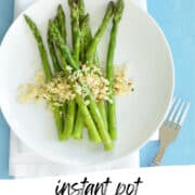 pressure cooked asparagus on a white plate topped with parmesan bread crumbs