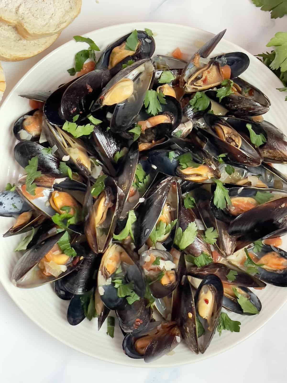 instant pot mussels mariniere on a white plate and topped with parsley