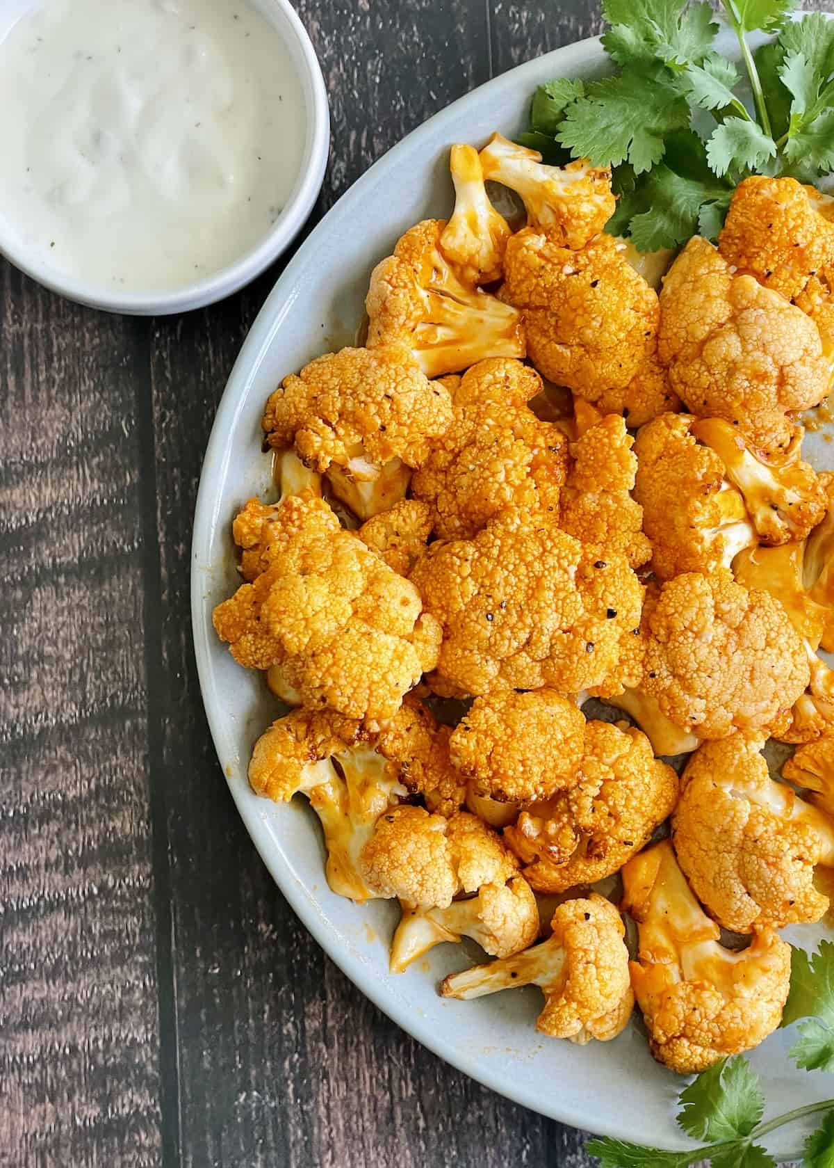 air fryer buffalo cauliflower on a gray plate served with ranch dressing