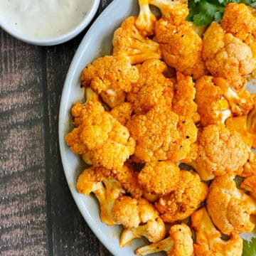 air fryer buffalo cauliflower on a gray plate served with ranch dressing
