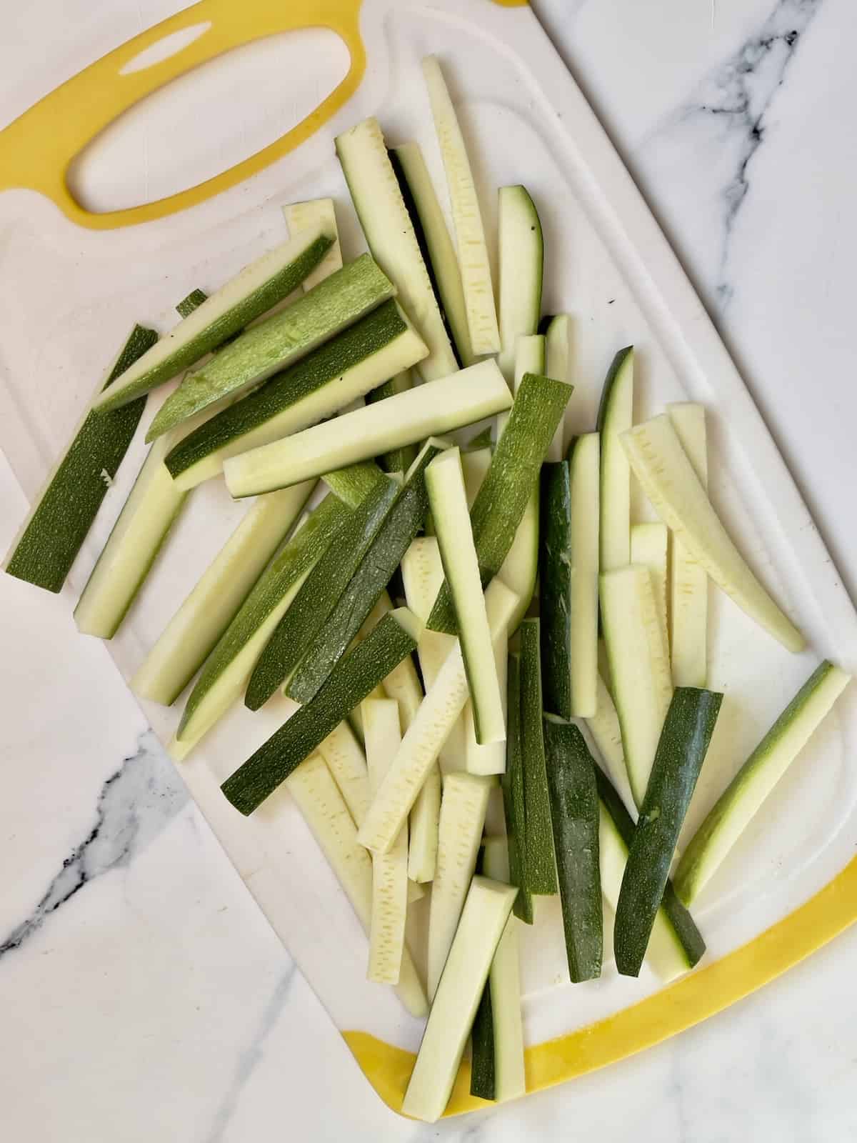 sliced zucchini sticks on a cutting board