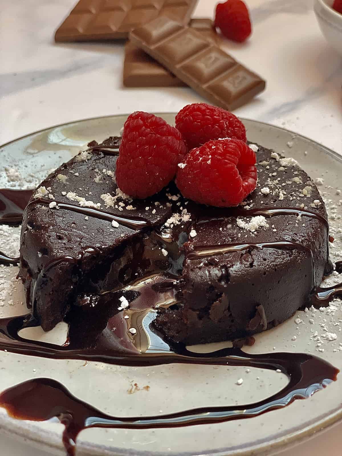 instant pot lava cake topped with chocolate syrup and raspberry