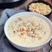 instant pot seafood chowder in a white bowl with oyster crackers