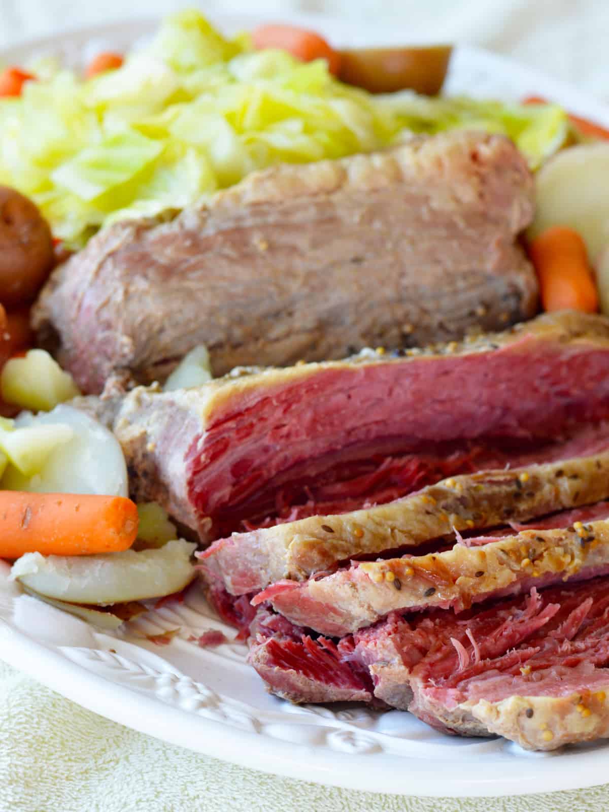 sous vide corned beef brisket on a plate with potatoes, cabbage and carrots