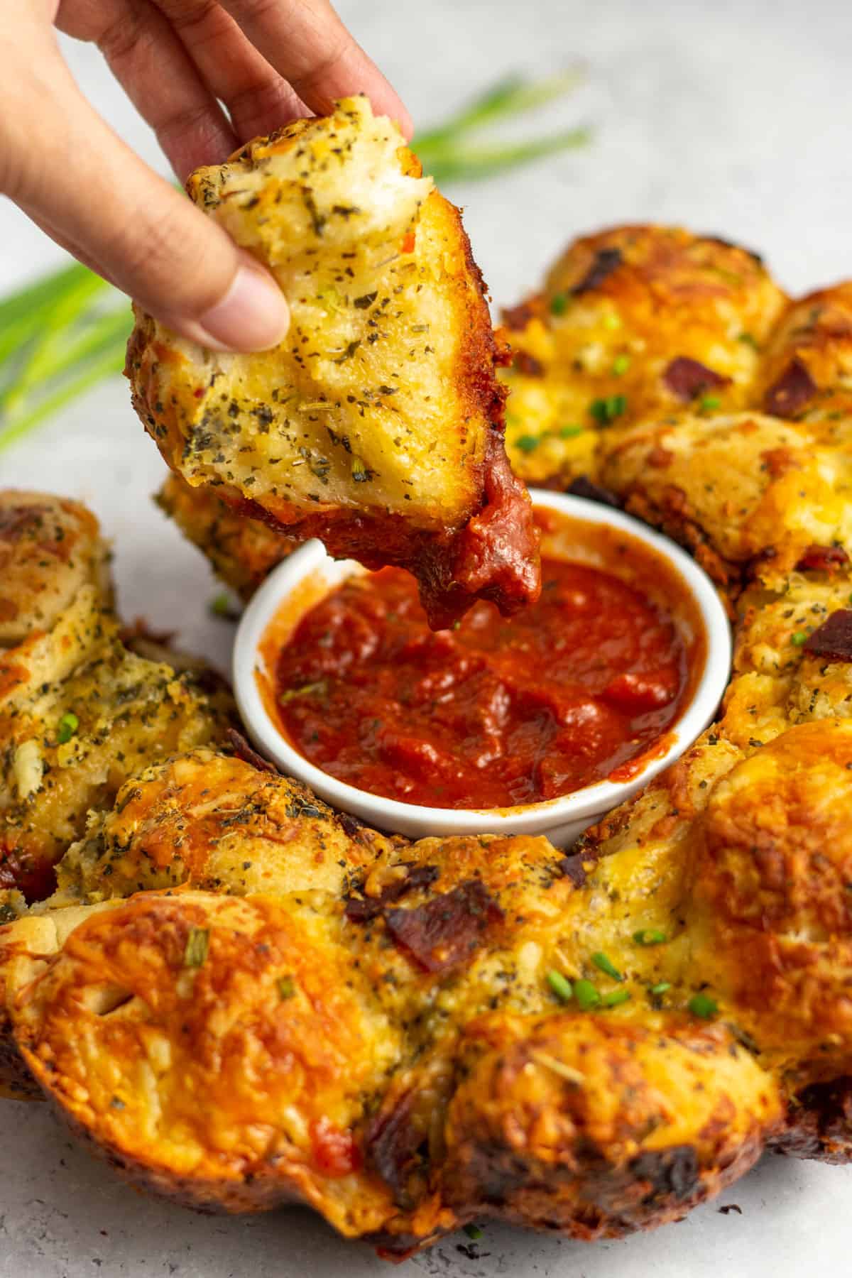 bacon pull apart bread being dipped into marinara sauce