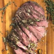 sous vide leg of lamb roast sliced on a cutting board