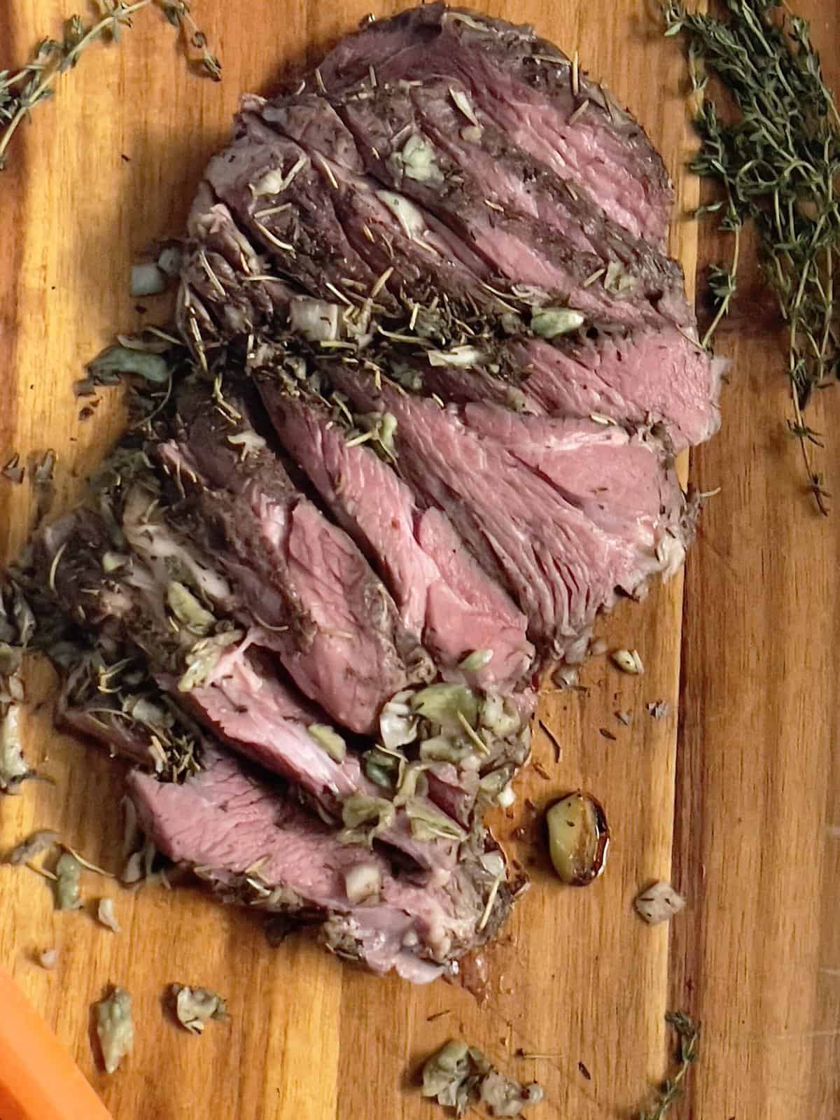 sous vide leg of lamb with rosemary garlic and spices on a cutting board