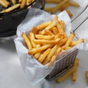 air fryer frozen french fries in a fry basket