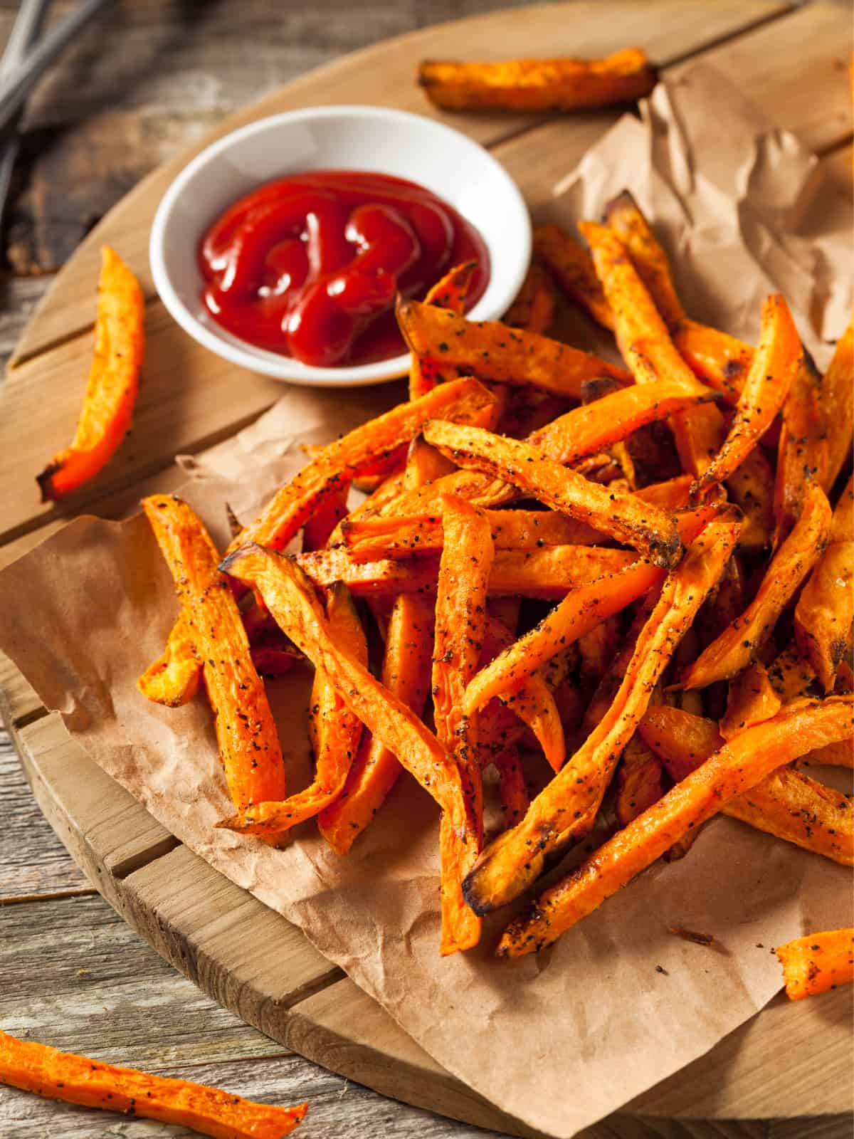 air fried crispy frozen sweet potato fries on parchment paper with ketchup