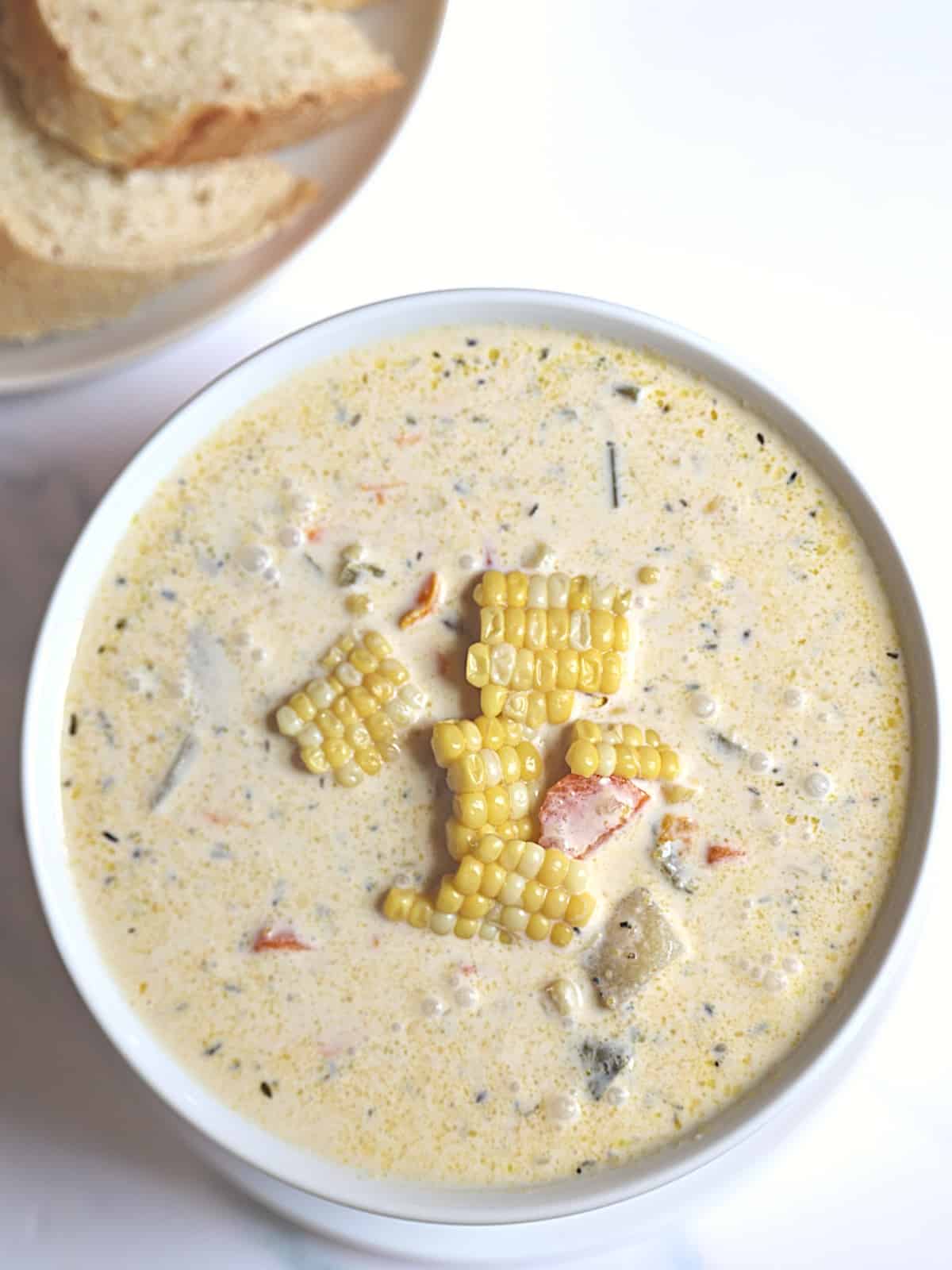 pressure cooked corn chowder in a white bowl served with bread