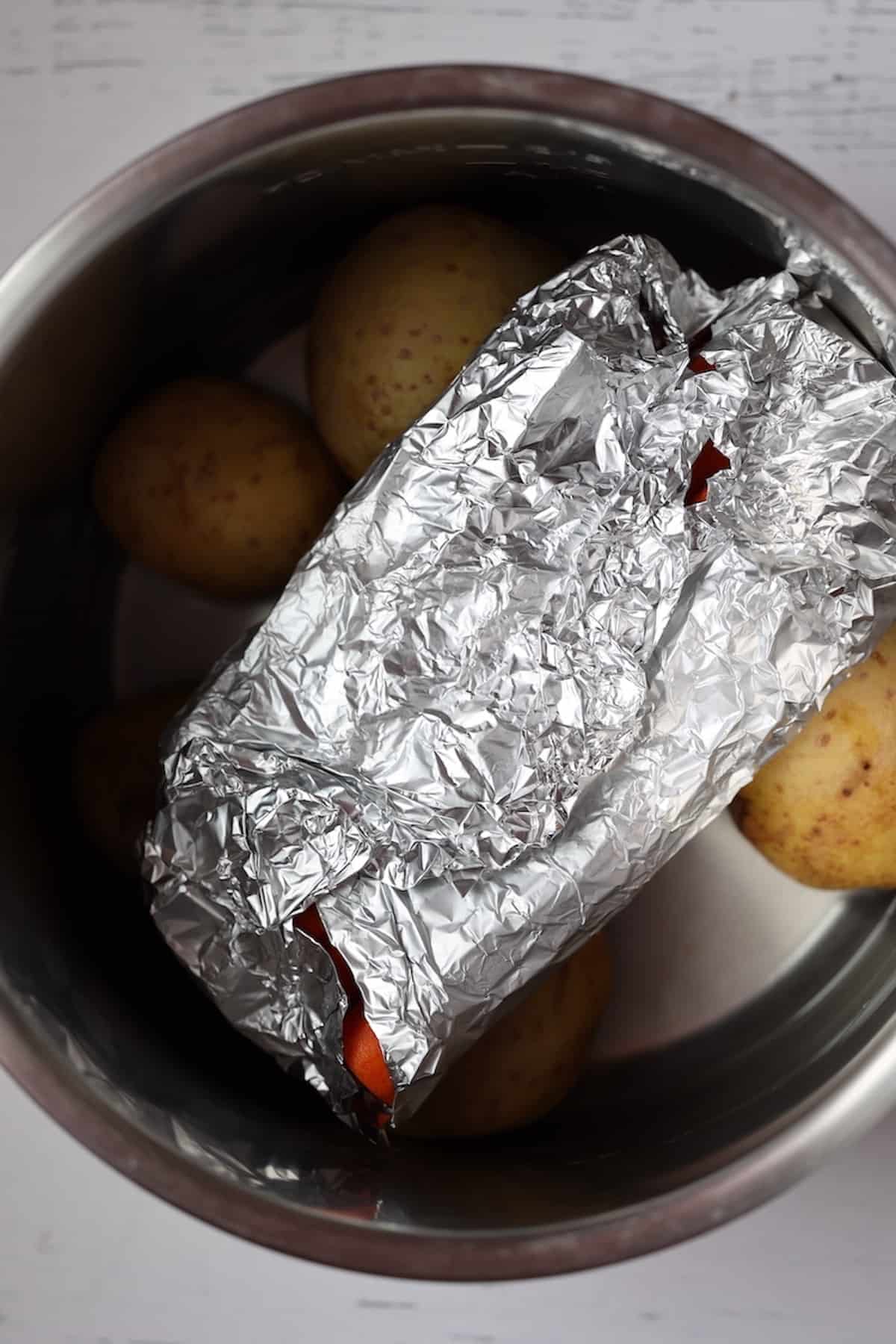 carrots wrapped in foil in a pressure cooker