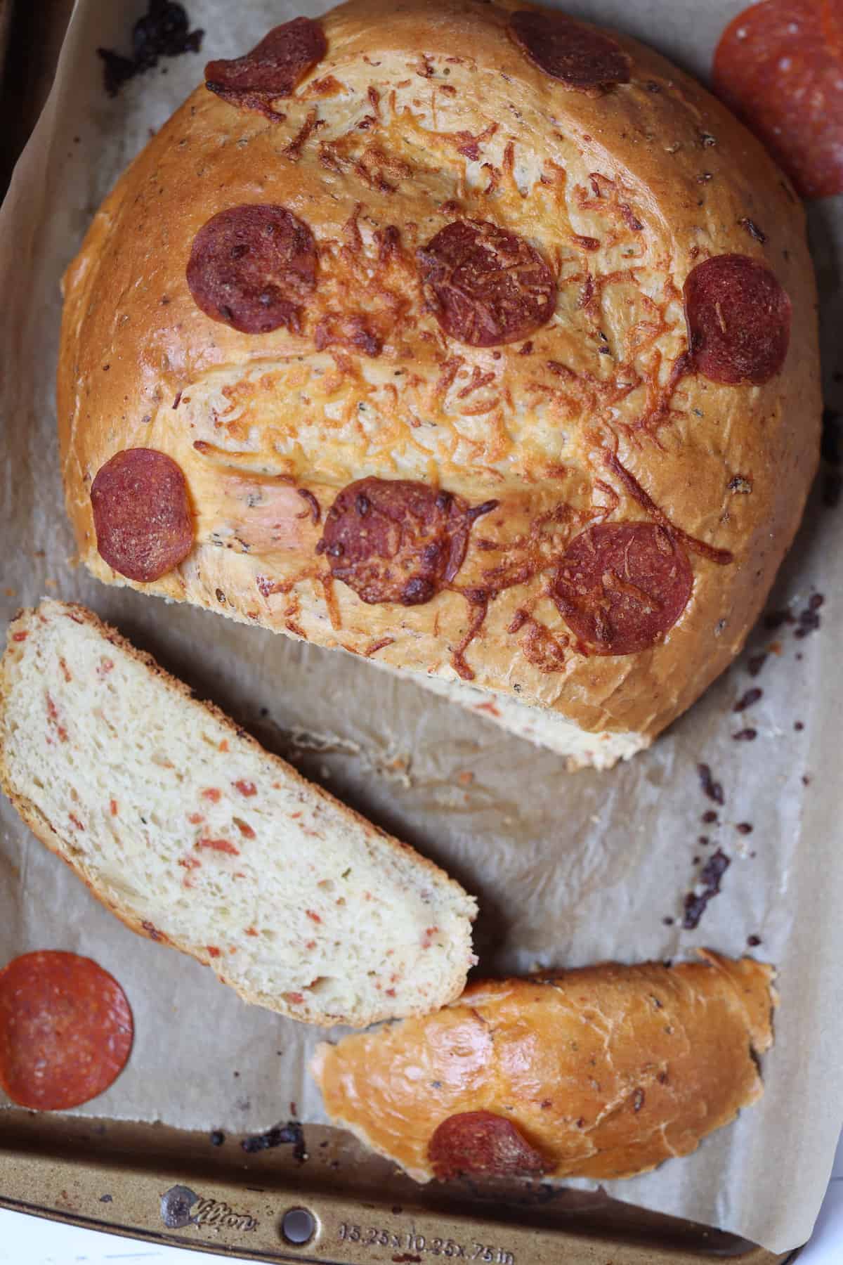 bread machine pizza bread on a baking sheet cut into 2 slices