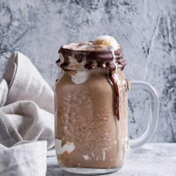 coffee milkshake in a glass mason jar drizzled with chocolate sauce
