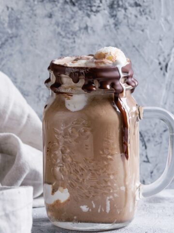 coffee milkshake in a glass mason jar drizzled with chocolate sauce