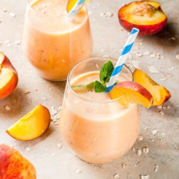 peach milkshakes in small glasses garnished with mint leave