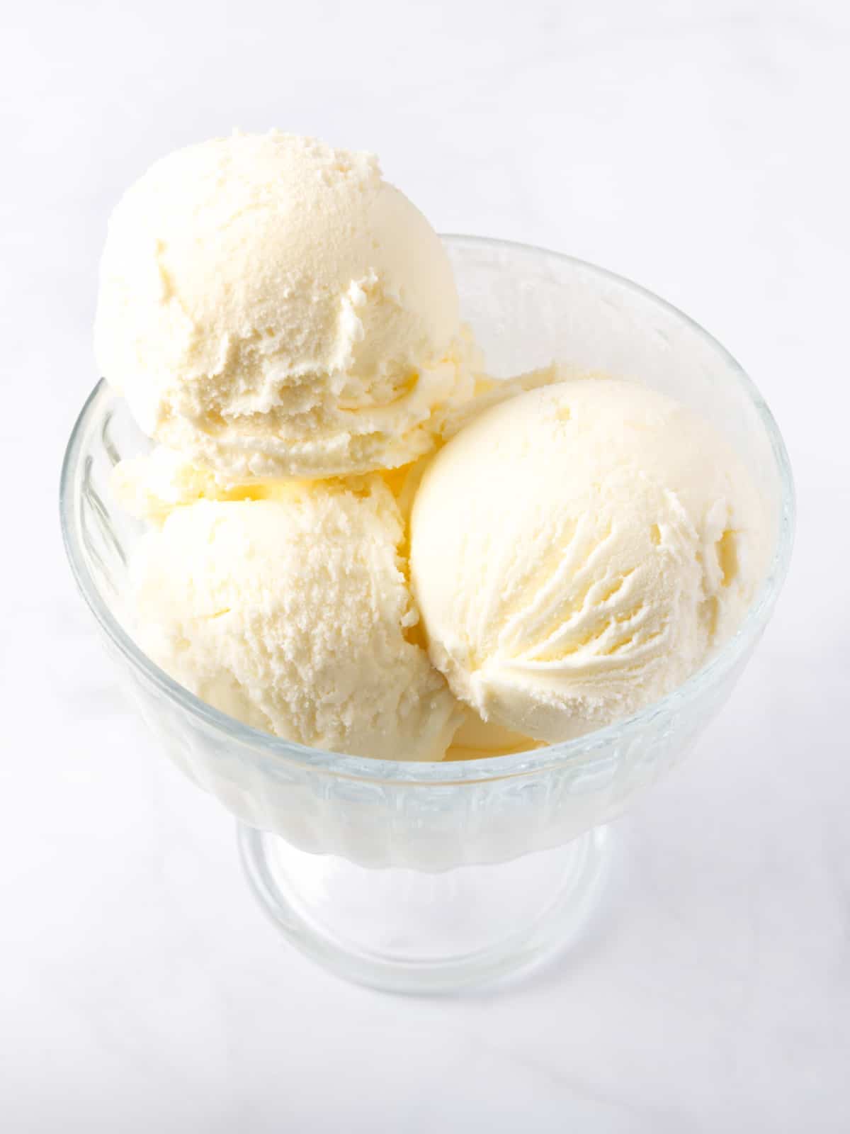 vanilla ice cream scoops in a glass bowl