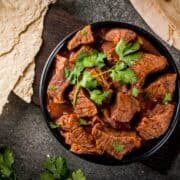 slow cooker chile rojo in a black bowl