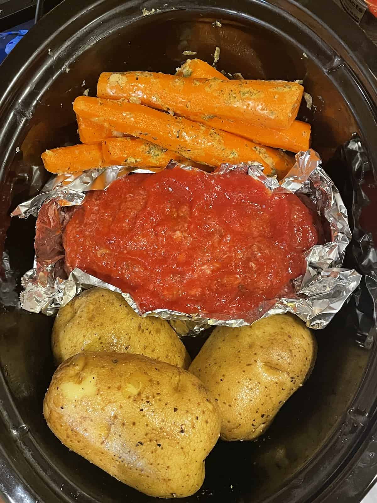 meatloaf, potatoes and carrots in a slow cooker