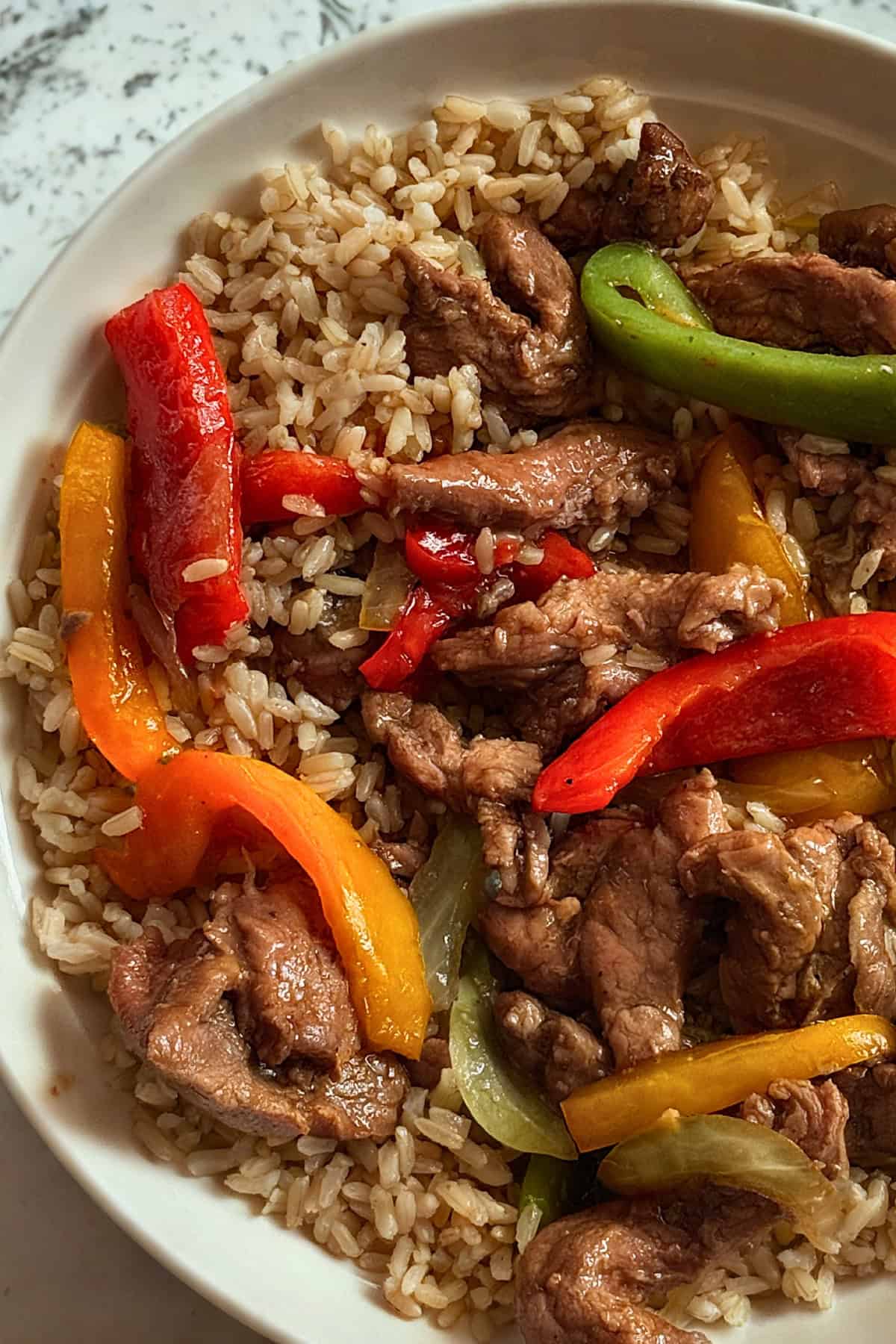 pepper steak in a bowl served over rice