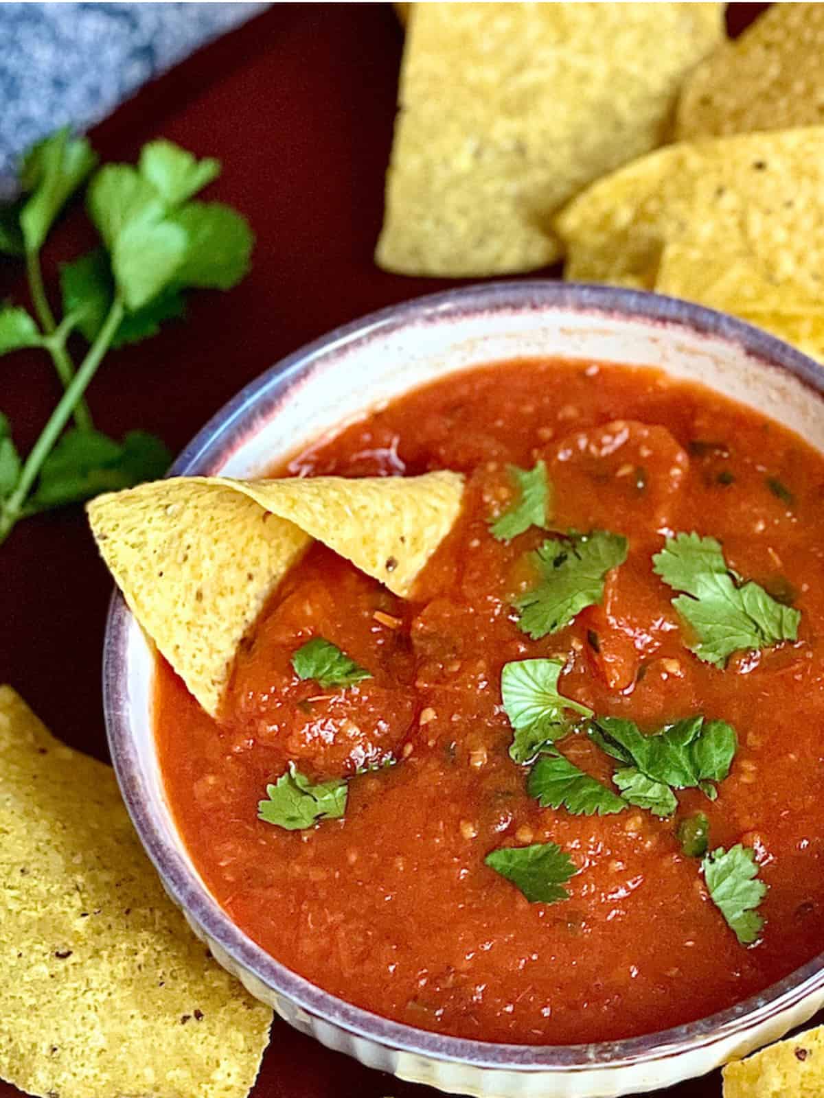 instant pot salsa in a bowl topped with cilantro and chips