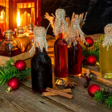 4 bottles of extracts on a wooden table with a Christmas lantern in the background