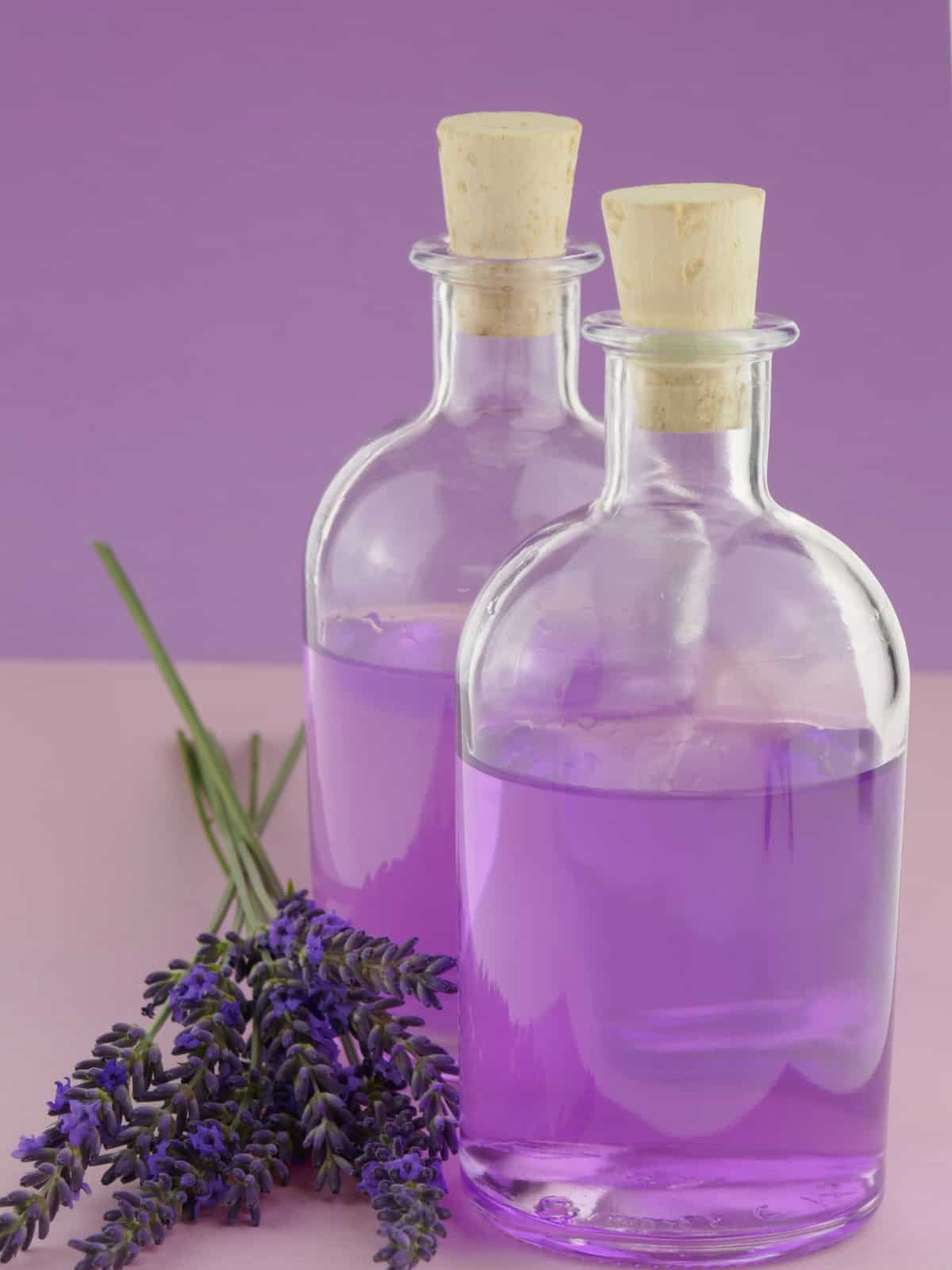 lavender extract in a glass bottle with lavender petals