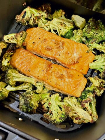 air fryer maple glazed salmon and broccoli in an air fryer basket