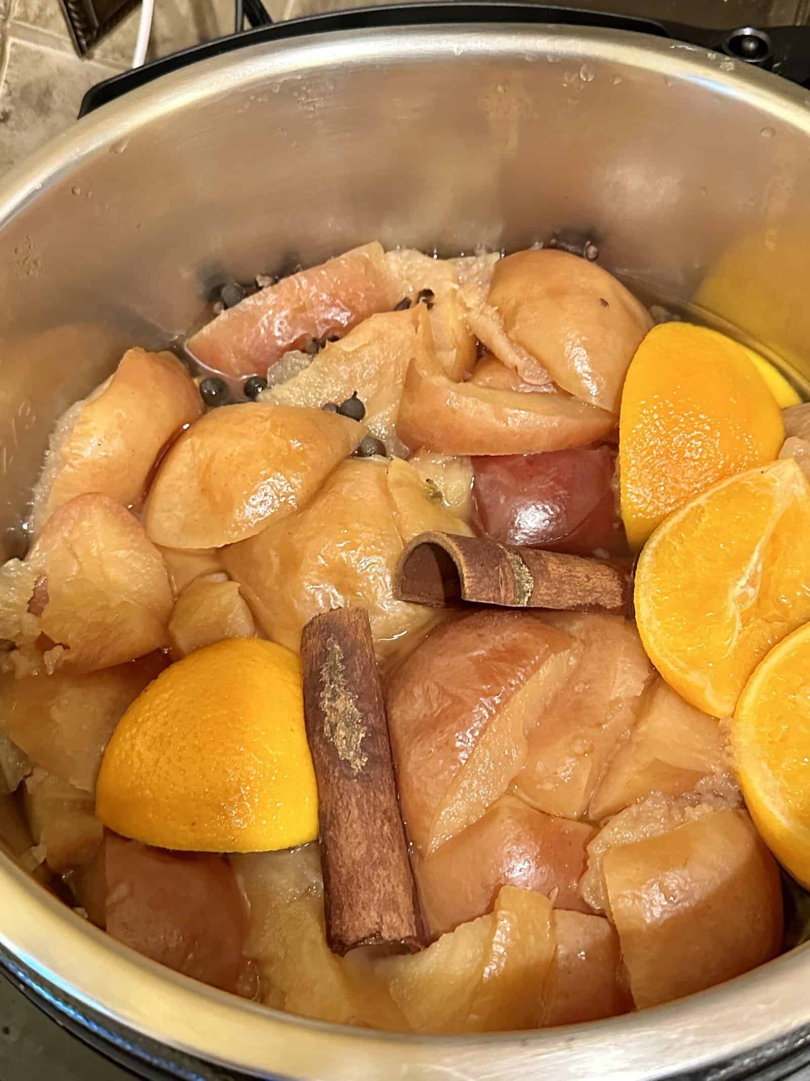 apples, oranges and whole spices cooked in a pressure cooker