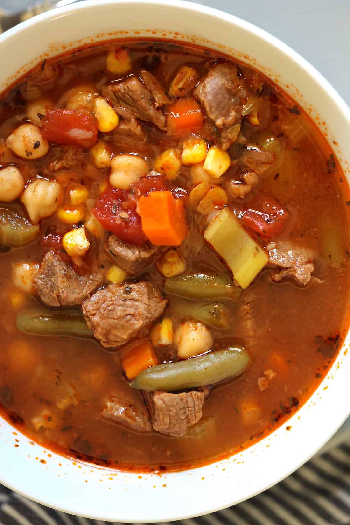 instant pot vegetable beef soup in a white bowl on a gray plate