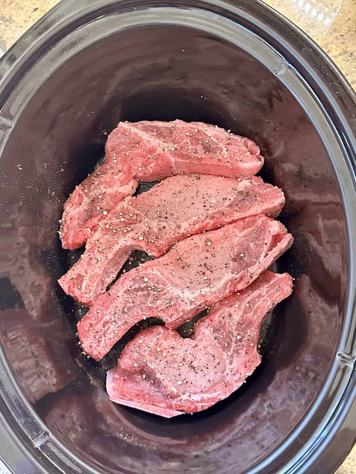 uncooked pork butt ribs in a slow cooker