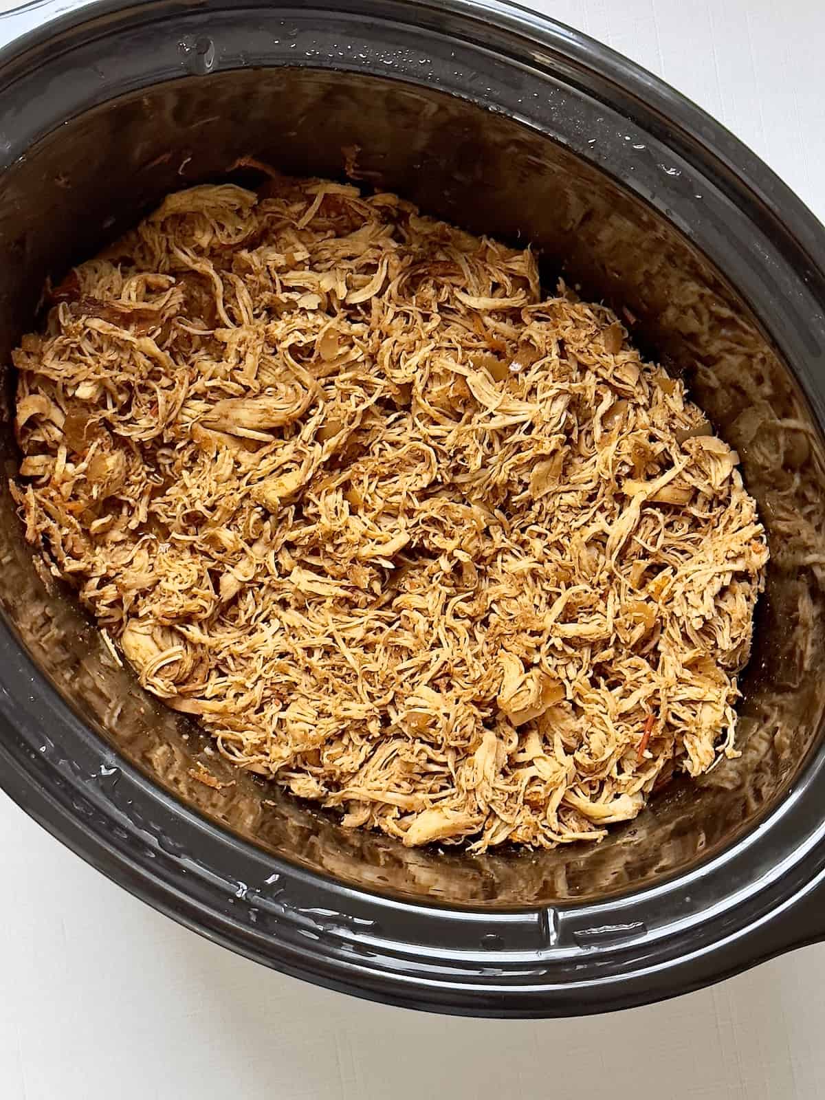 slow cooker shredded enchilada chicken in a crock pot