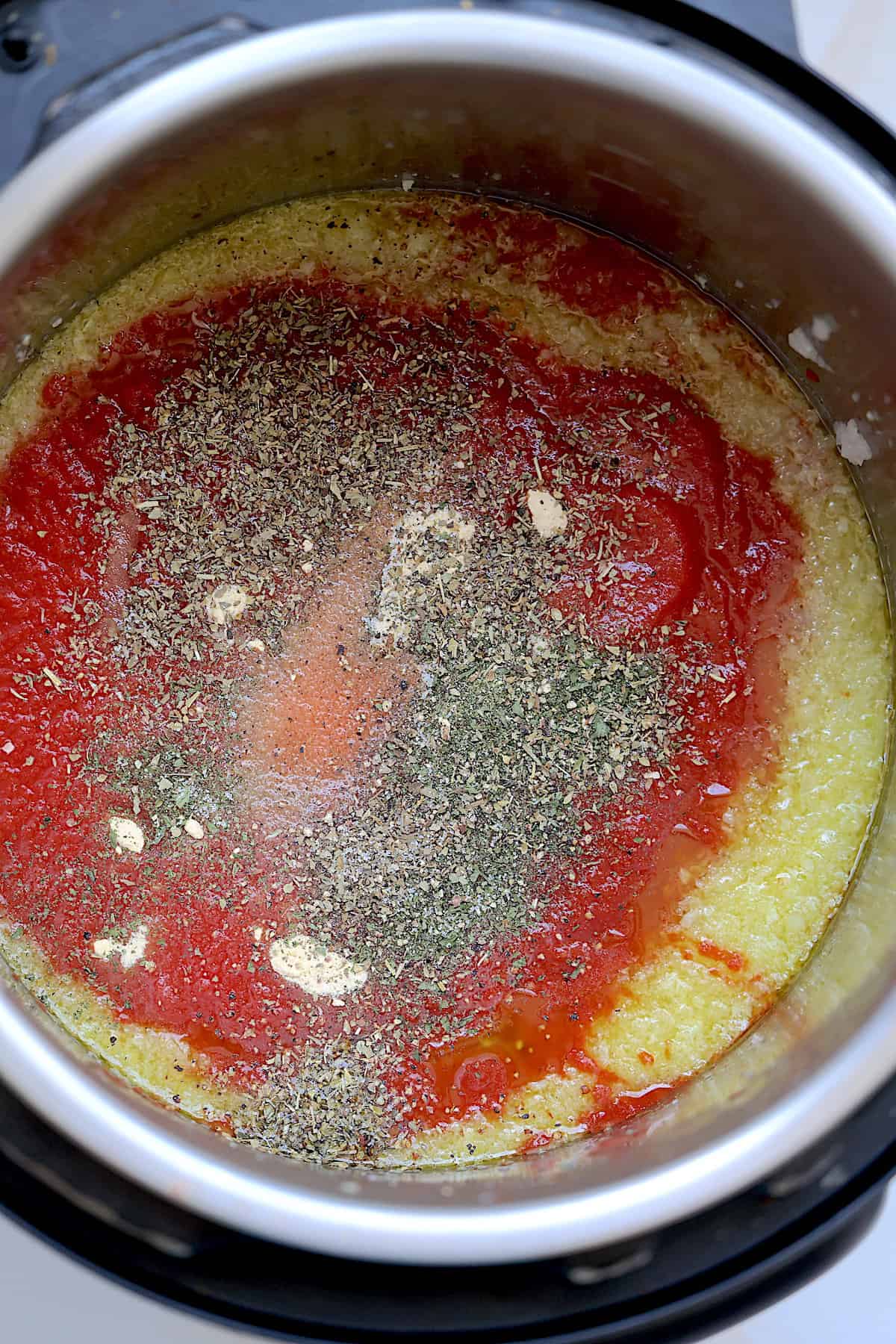onions, garlic, tomato sauce and seasonings in an inner pot of pressure cooker