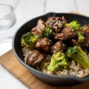 slow cooker beef and broccoli served over rice in a black bowl
