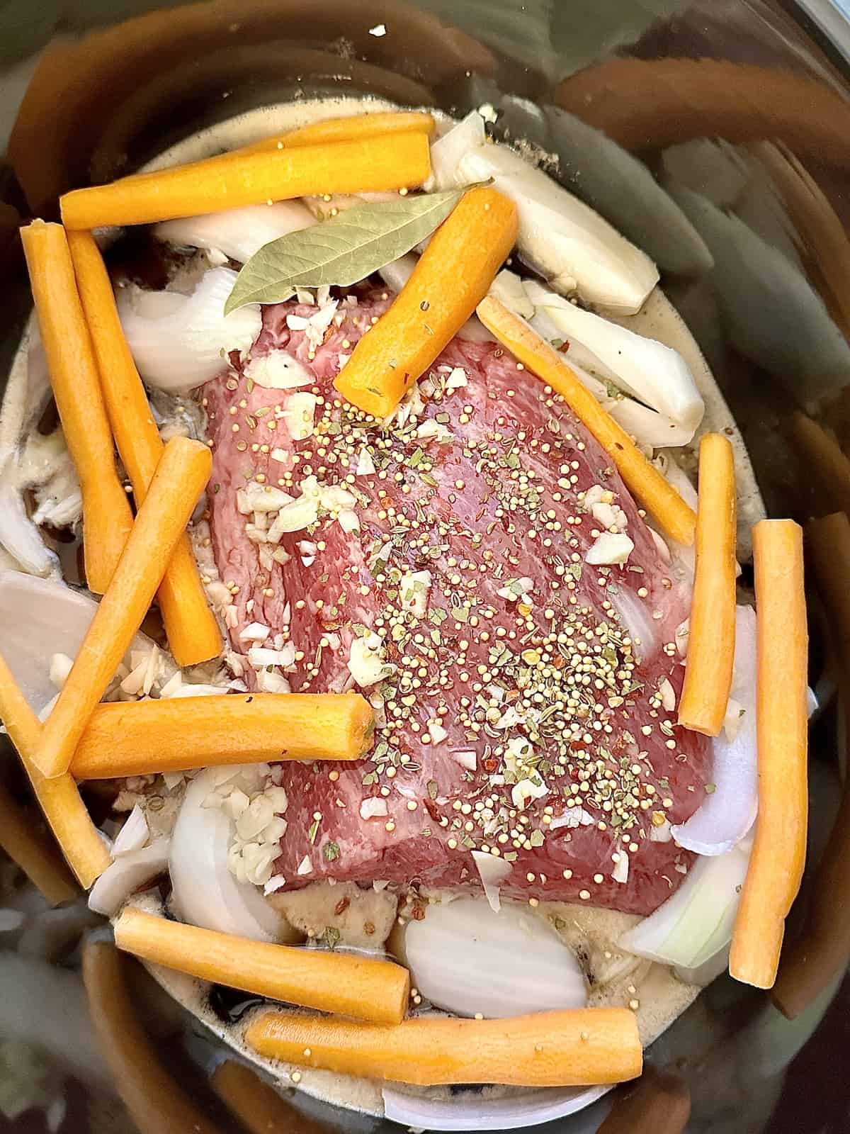 corned beef, onions, carrots and spices in a slow cooker