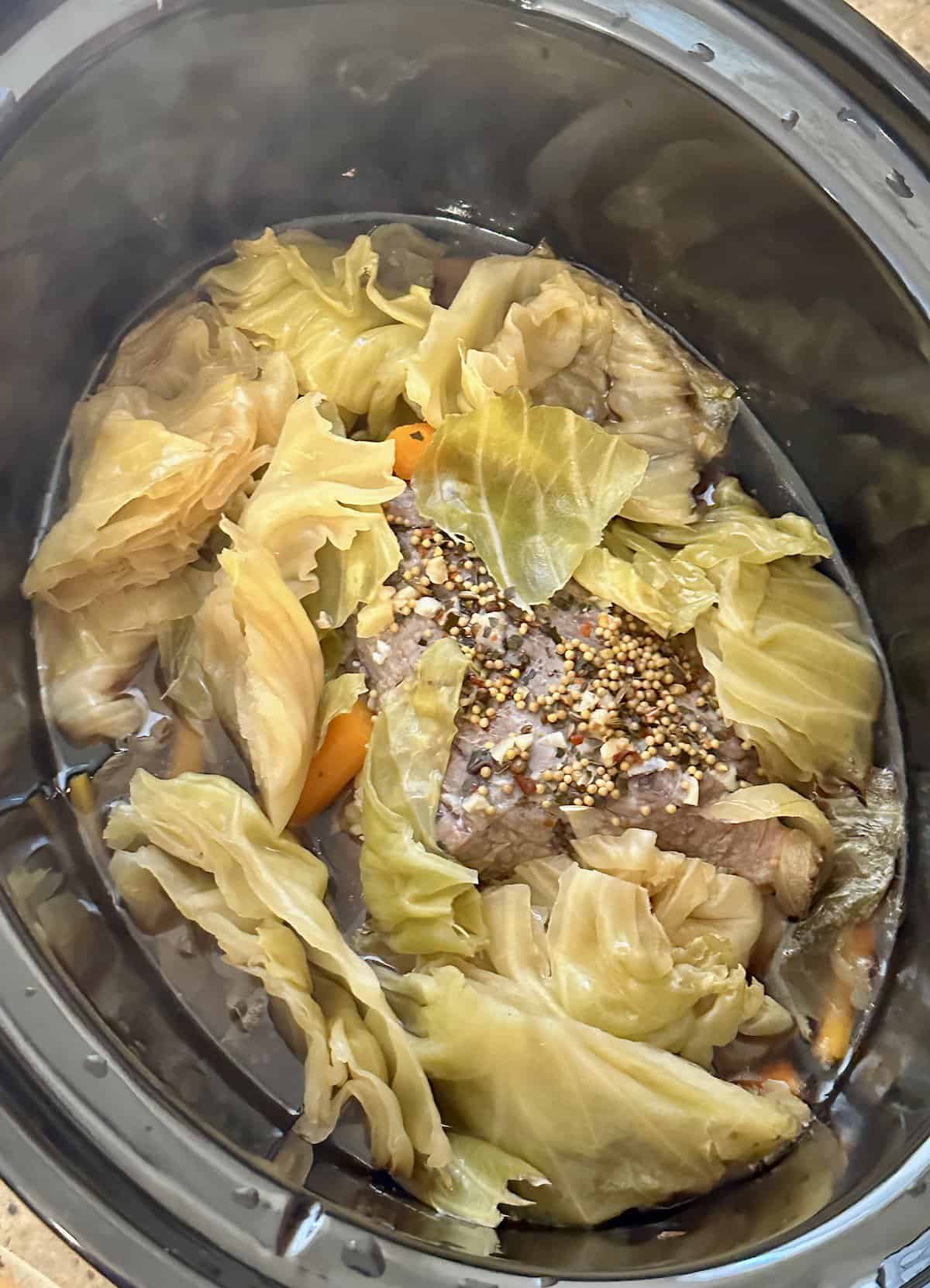 cooked cabbage, carrots and corned beef in a crock pot