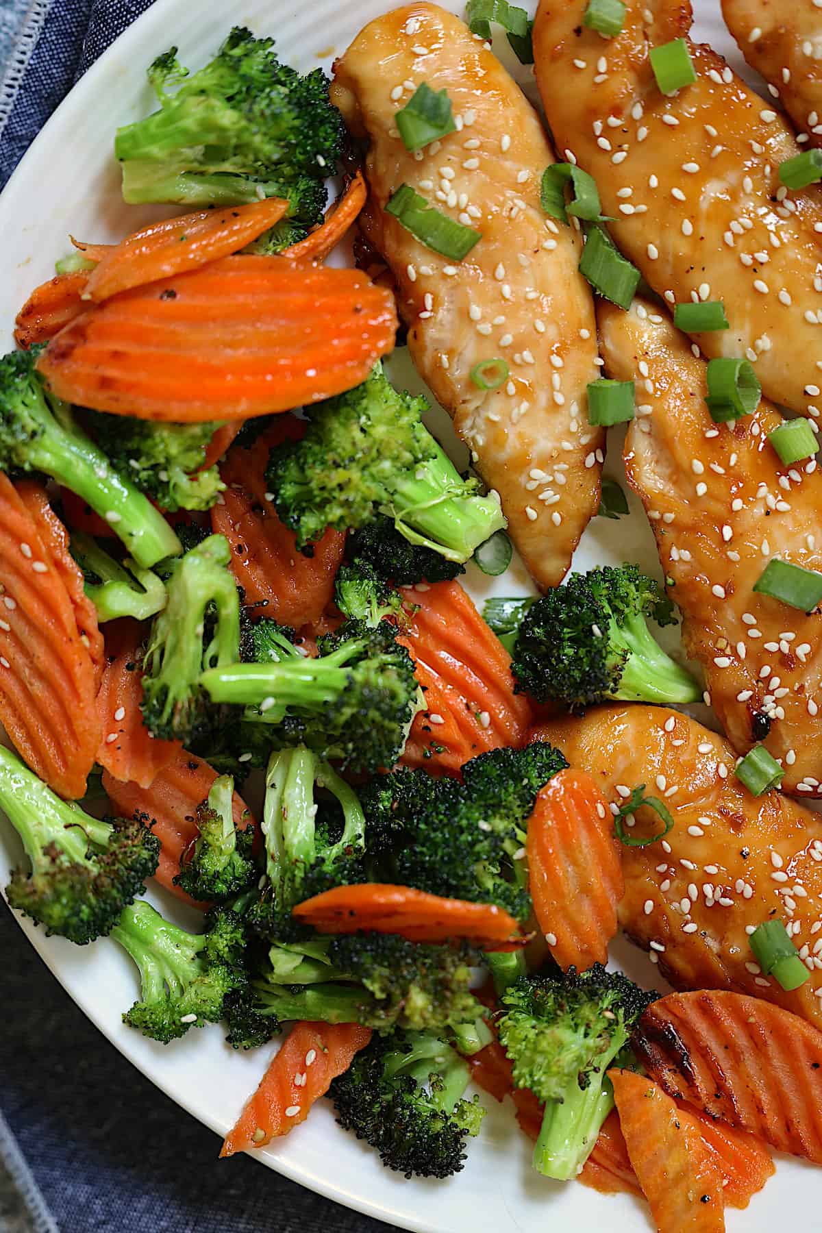carrots, broccoli and teriyaki chicken on a white plate