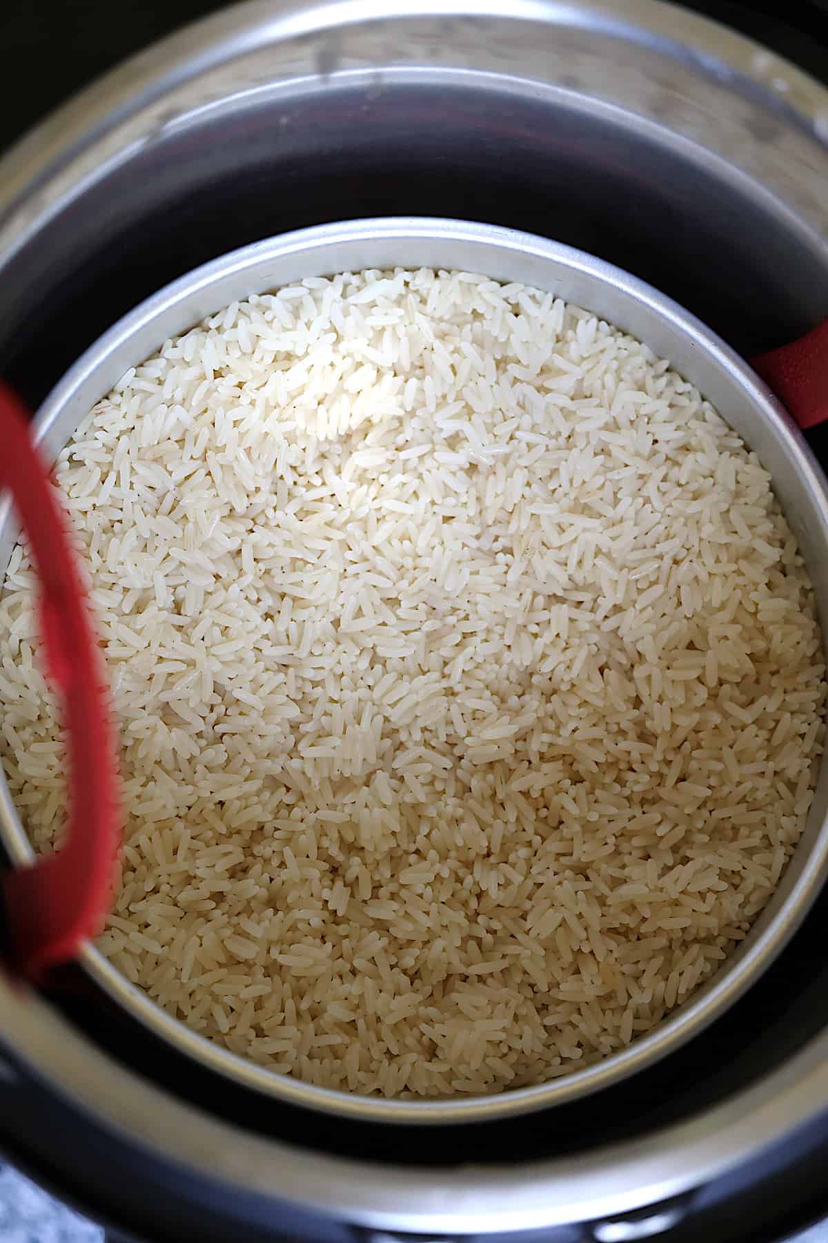 white parboiled rice in a pressure cooker on a silicone sling
