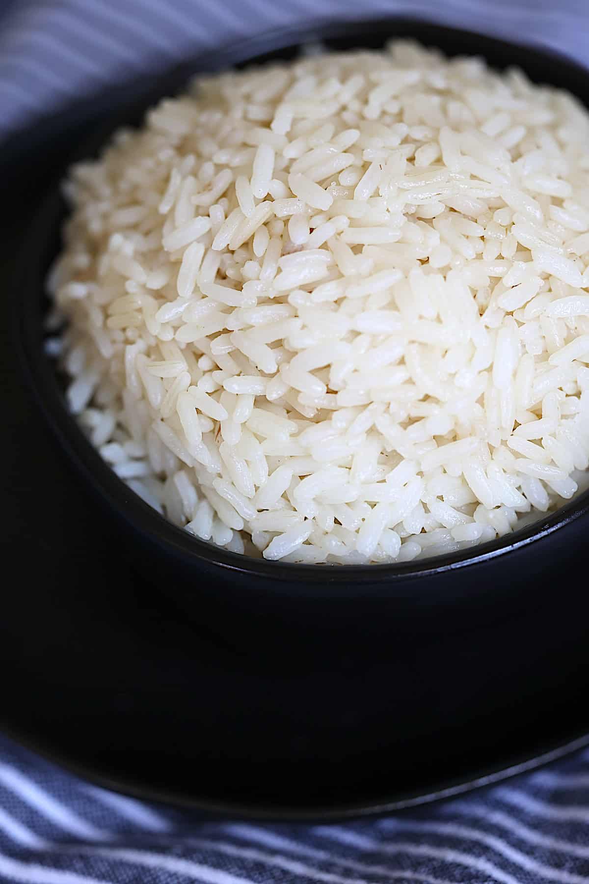 close up of pressure cooked white rice in a black bowl