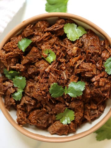 instant pot shredded beef in a bowl topped with cilantro