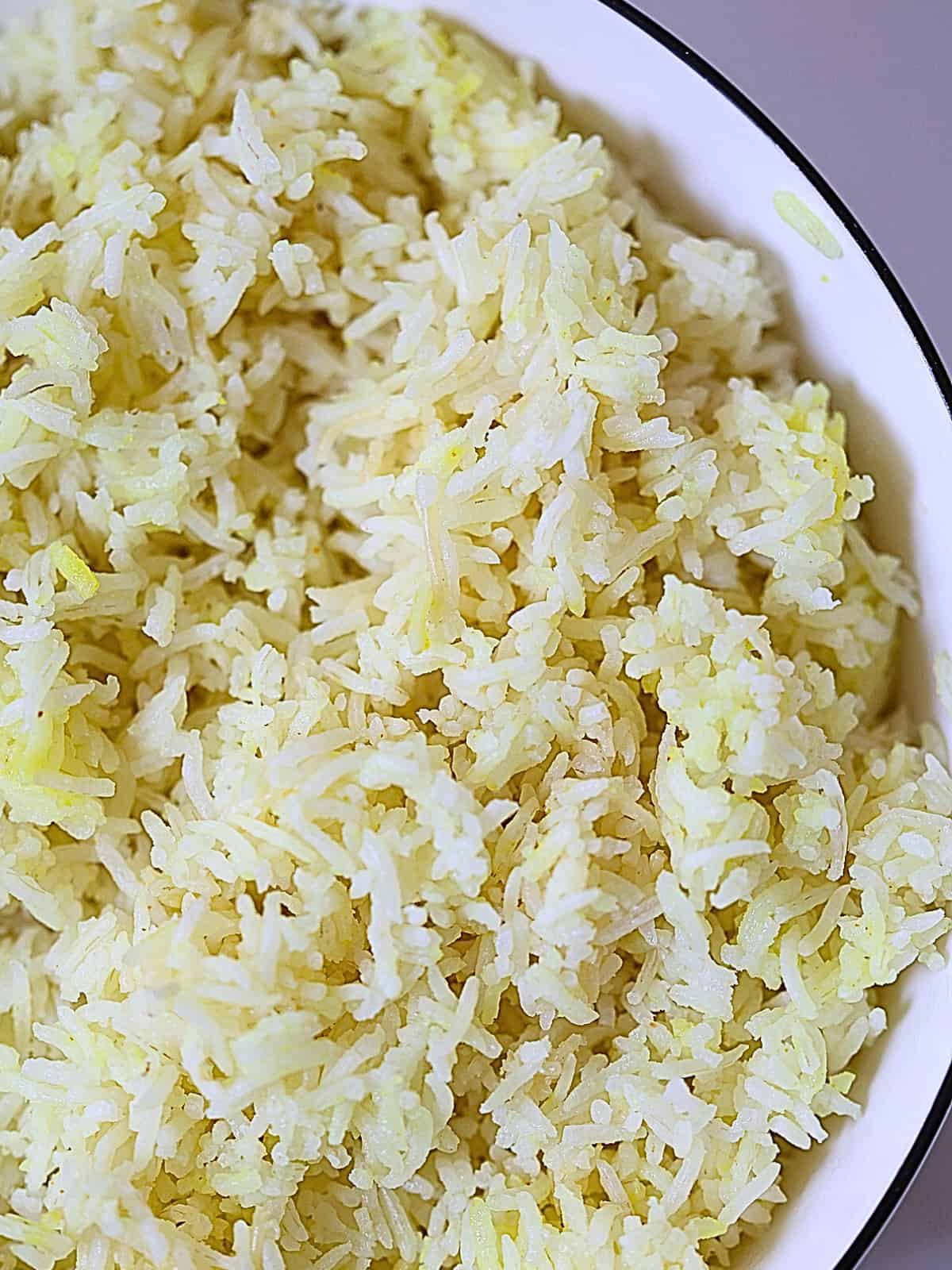 Instant pot white basmati rice colored yellow with saffron in a white bowl