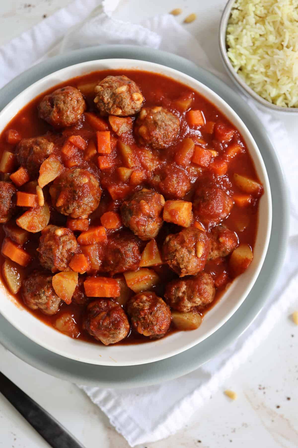 slow cooker lamb meatballs, potatoes and carrots in a white bowl