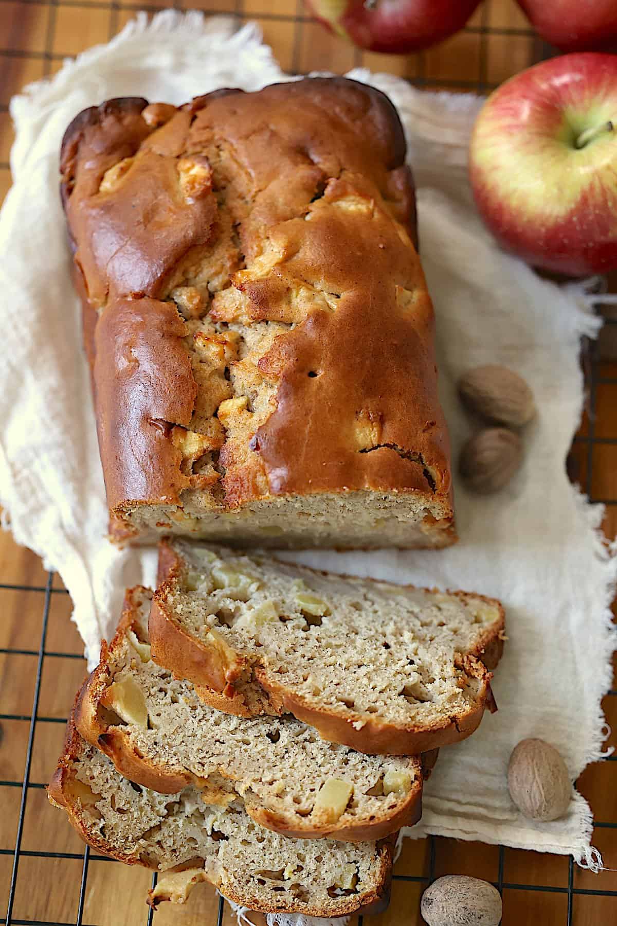 apple bread loaf cut into slices on a cutting board