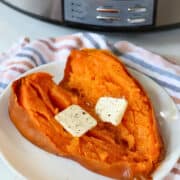 slow cooked whole sweet potato with butter on a serving plate
