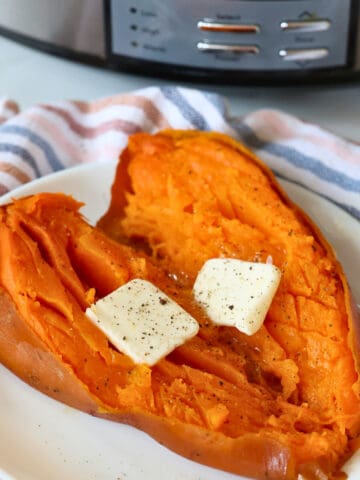slow cooked whole sweet potato with butter on a serving plate